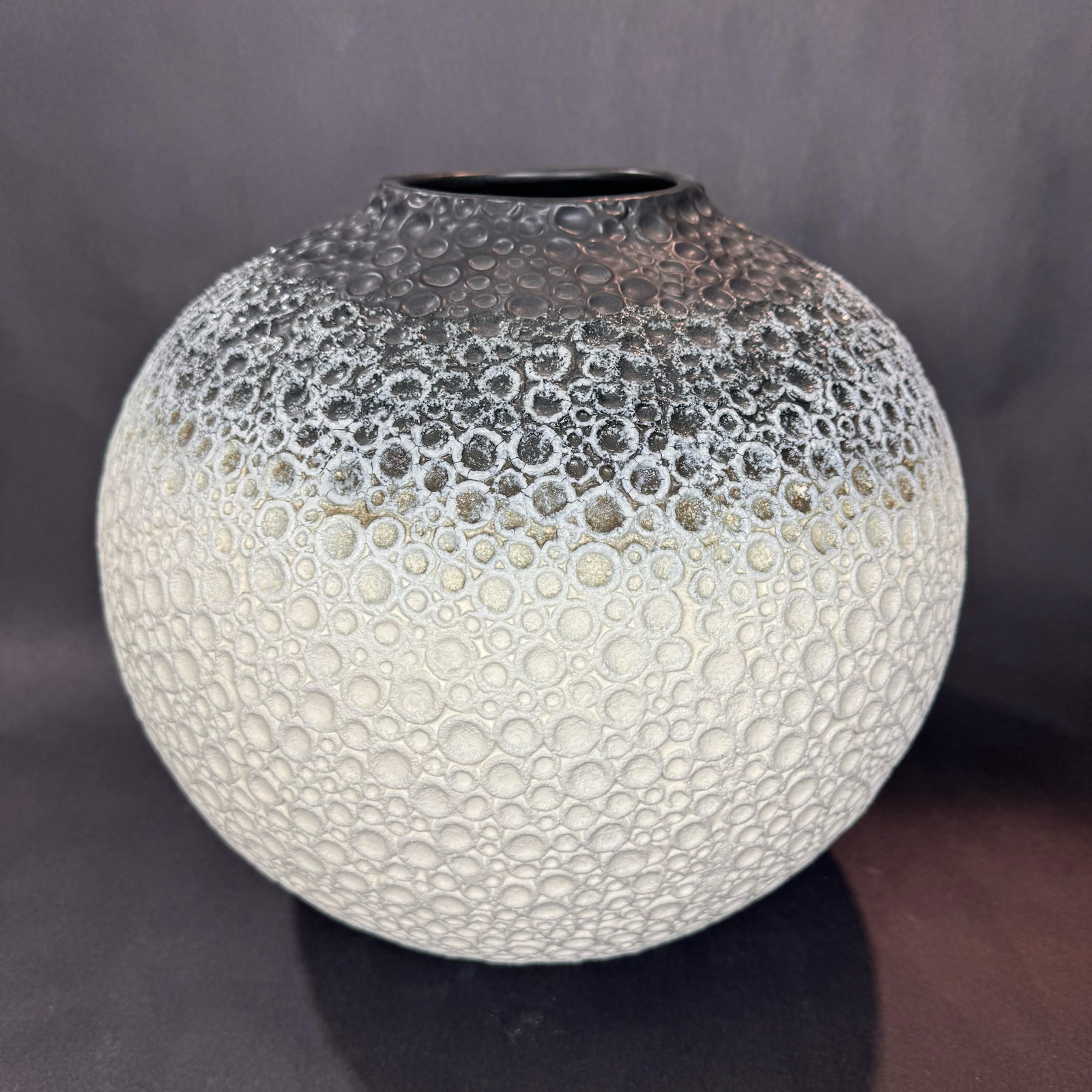 Global Views 14” H x 15” W Ceramic Vase: Artist: Global Views Title: Celestial Black & White Vase Medium: Ceramic Size: 14” H x 15” W x 15” D Weight: 11.2 lbs. Edition: Open This celestial-inspired vase features a round