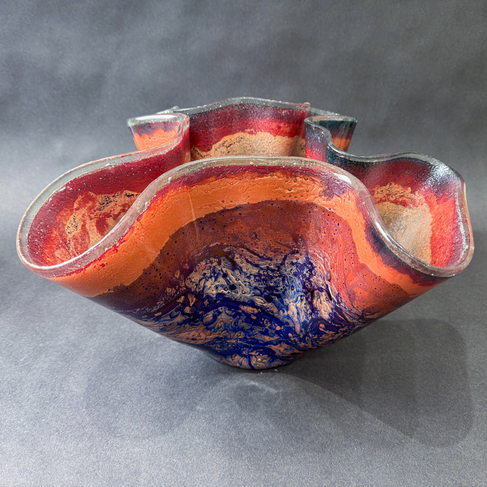 Jones Glassworks 9.5" H x 14.5" W Handkerchief Wave Vase: Artist: Jones Glassworks Title: Handkerchief Wave Vase Medium: Fused Art Glass on Copper Artwork Size: 9.5" H x 14.5" W x 13" D Weight: 7 lbs. Edition: Unique This dramatic glass vase features swe