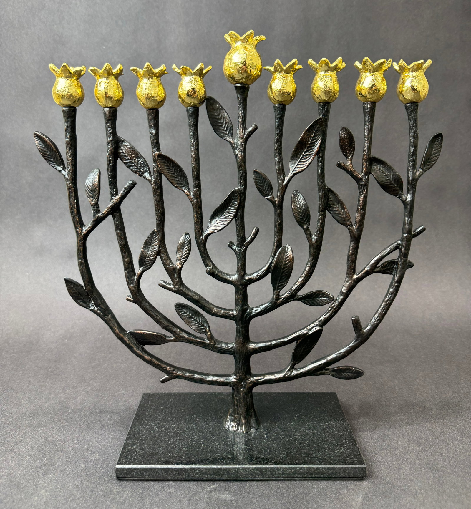Michael Aram 12.5" H x 12" W Pomegranate Menorah Retired: Artist: Michael Aram (b. 1963) American-Armenian Title: Pomegranate Menorah (Retired) Medium: Natural & Oxidized Brass Artwork Size: 12.5" H x 12" W x 4" D Weight: 2.25 lbs. Edition: Open This scul