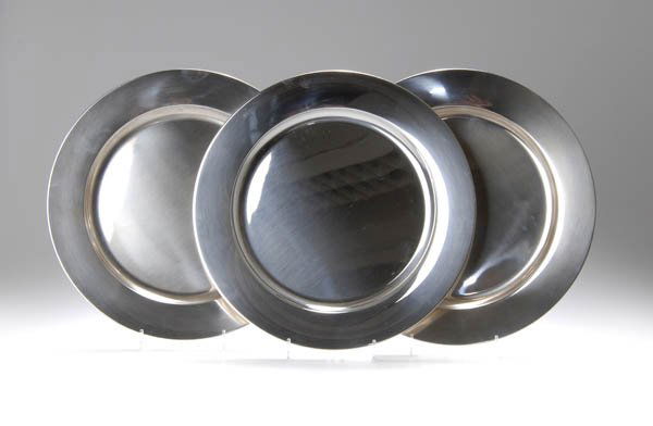 Henning Koppel, Six Place Plates, 1959: Round; higher rim, flat flaring. Dm 28 cm. Execution: Georg Jensen, Copenhagen, 1977. Silver. Reverse marked: C 10 (Year mark), DESSIN HK (in oval), DENMARK, Marke GEORG JENSEN, STERLING. 1074 A. Mode