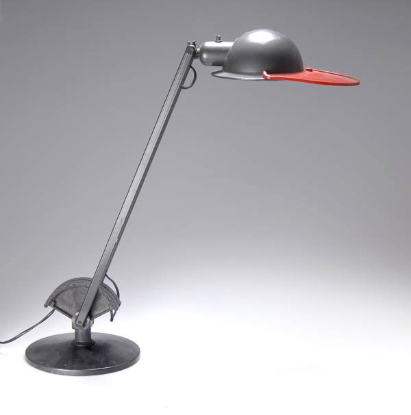 Perry King, Santiago Miranda, Gianluigi Arnaldi, T: Flat stand with iron weight. Metal, gray and white enamel, mounting in black synthetic, reflector with element in red synthetic resembling peck of a duck. H. (maximum) 91 cm. Executed by Arteluce, Mil
