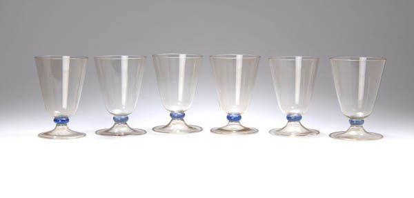 Karl Bertsch, Sechs Rotweingläser, 1929: Tiefe, schrägwandige Kuppa, Linsennodus, flach ausgestellter Rundstand mit hohlem Schaftansatz, aufgetriebene Randkante. H. 14 cm. Ausführung: M.V.M. Cappellin e C., Murano. Zart rauchbraun getönte