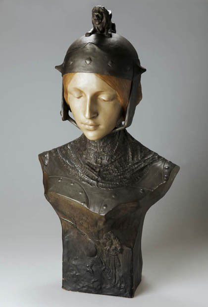 Ezio Ceccarelli, Büste einer Frau mit Helm, um 190: Ausführung vermutl. Keramikfabrik Friedrich Goldscheider, Wien. Sandfarbener Steingutscherben, in der Art von Bronze braun patiniert u. ockerfarben bemalt. Rückseite bez. u. sign.: Prof. E. Ceccarel