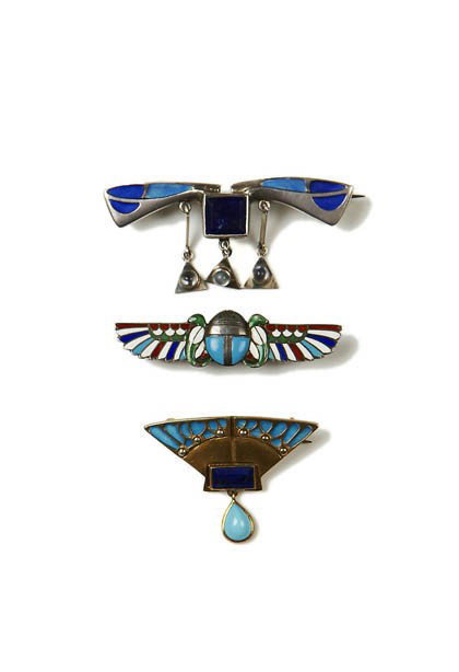 Pforzheim, Brosche, um 1902: Zweiflügelige Form mit drei Pendelanhängern. Silber, Mattemail in Hell- u. Dunkelblau, facettierter Lapiszlazuli in Zargenfassung. Bez.: DEPOSE, 900. 2,5 x 5,5 cm.