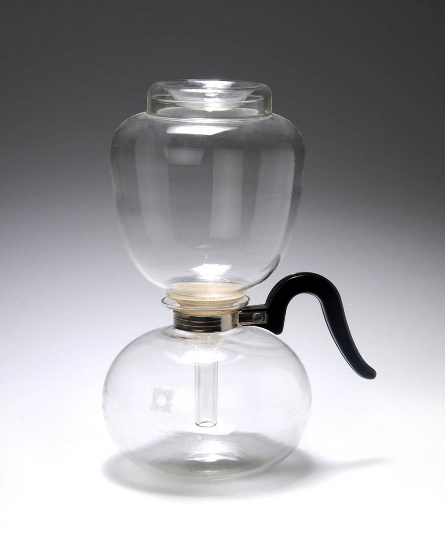 Wilhelm Wagenfeld, Kaffeemaschine 'Sintrax', um 1: Zweiteiliger Aufbau. Kanne mit Kunststoffgriff und Metallmanschette, Aufsatz mit Siebeinsatz, Gummidichtung u. Deckel, Deckelkappe für die Kanne. Ausführung: Jenaer Glaswerk, Schott & Gen., Jena. Fa