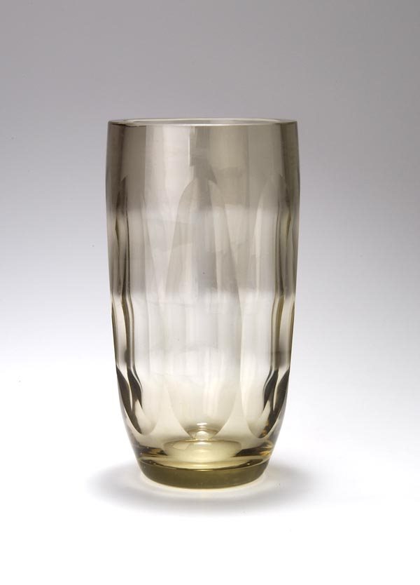 Elis Bergh, Vase, um 1935: Zylindrische Form, zum Stand eingewölbt. H. 20 cm. Ausführung: Kosta Glasbruk, Schweden. Rauchgelb getöntes, horizontal rippenoptisch geblasenes Glas, Außenwandung mit umlaufenden Hochovalen in po