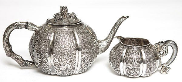 A Chinese silver teapot and creamer, both ornately (1 of 3)