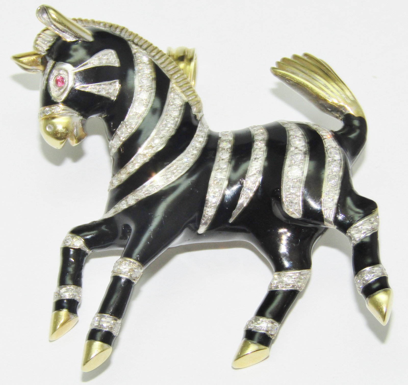 18Kt Gold and Enamel Zebra Pendant with Diamonds and Rubies: 18 karat yellow and white gold Zebra pendant with black enamel, diamond melee in the stripes and has Ruby eyes. 37.9 grams. Appraised Fair Market Value (FMV) is $2000.