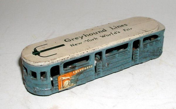ARCADE NEW YORK WORLD'S FAIR BUS: ARCADE NEW YORK WORLD'S FAIR BUS circa 1939 - 6 ½" long. This seldom encountered bus is in pristine condition in all regards. Lettering, paint, and Greyhound decals are outstanding. Black rubber tire
