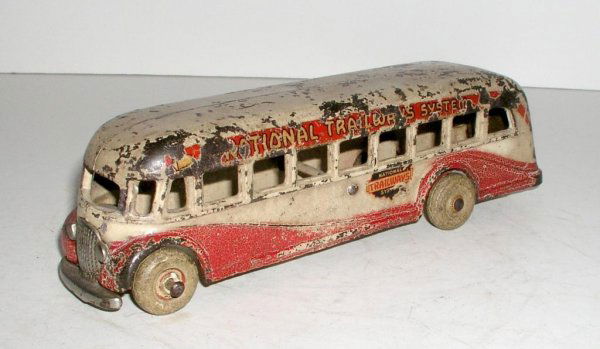 ARCADE NATIONAL TRAILWAYS BUS: ARCADE NATIONAL TRAILWAYS BUS circa 1937 - 9 ¾" long. Painted ivory with red trim. Nickeled radiator,lights, front bumper and rear panel. White rubber tires with red centers. Very popular and difficu