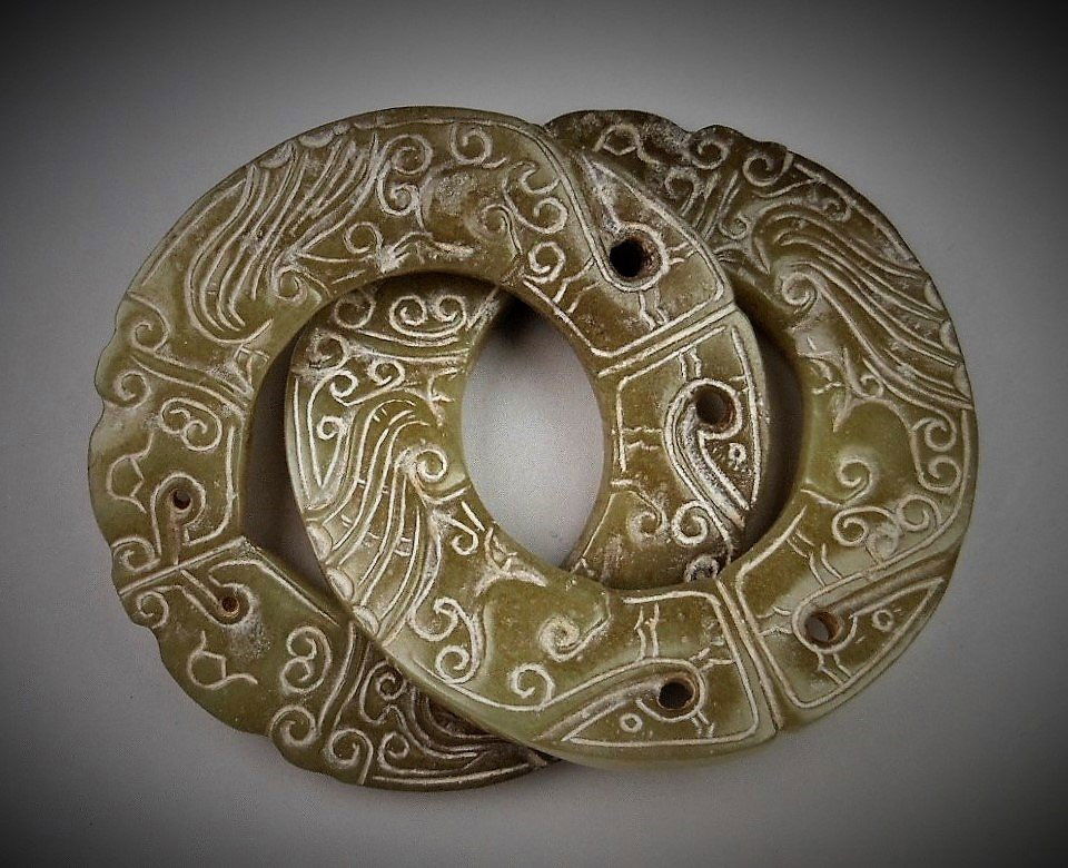 A CHINESE ARCHAIC ROTUNDITY-SHAPED JADE DOUBLE -DRAGON: WARRING STATES PERIOD 770-221 B.C. A CHINESE ARCHAIC ROTUNDITY-SHAPED JADE DOUBLE -DRAGON, RINGS D : 2.6 inx2 (6.6 cmx2) Provenance: Property from a private Taiwan collector, purchased in 1930 from Ho