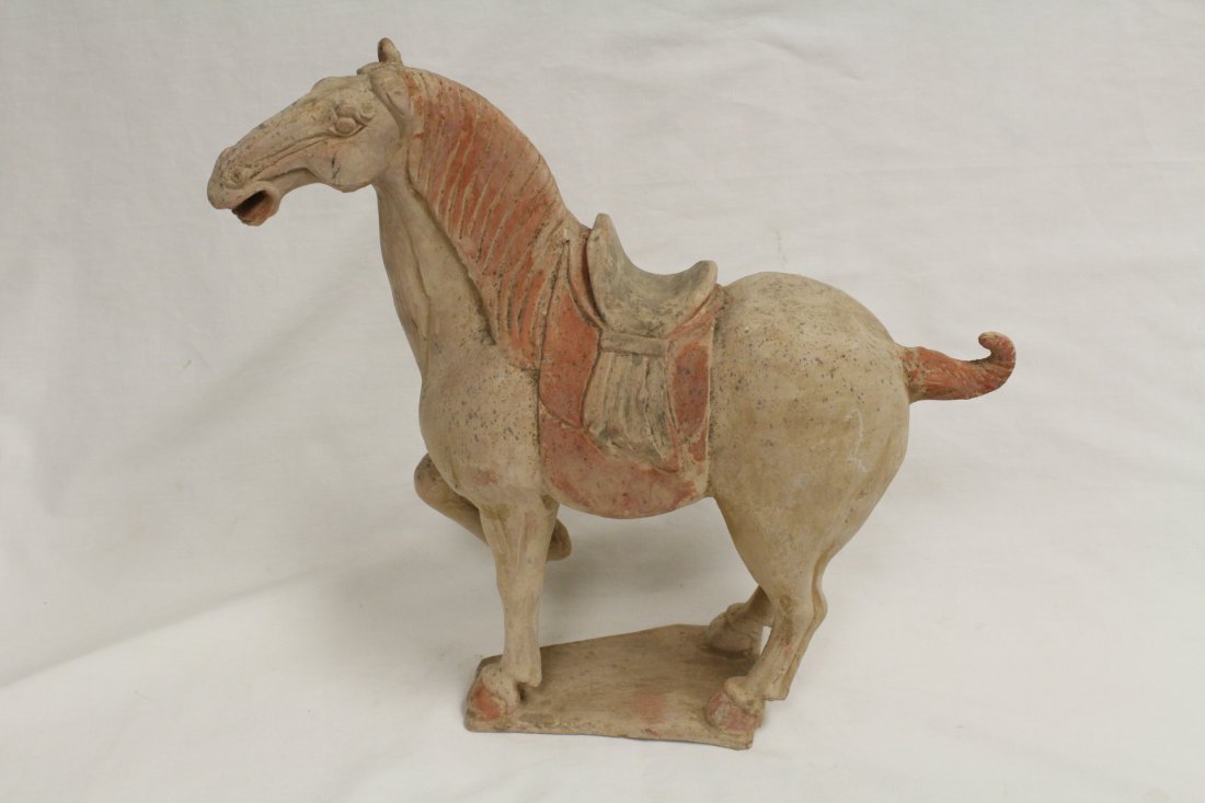 A CHINESE HAN DYNASTY POTTERY HORSE: A CHINESE HAN DYNASTY POTTERY HORSE, LOSS OF ONE EAR. H: 13.3 in (34.4 cm)