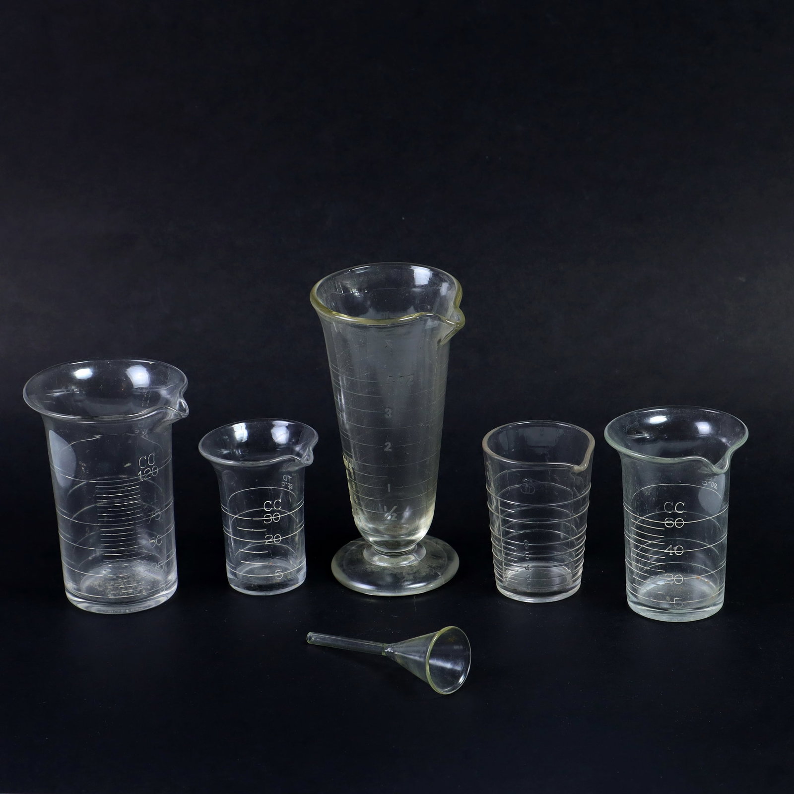 Antique Science Lab medical apothecary measuring glass beakers and a mini funnel: Antique Science Lab medical apothecary measuring glass beakers and a mini glass funnel, sizes 3, 3.5, 4, and 6 inches tall