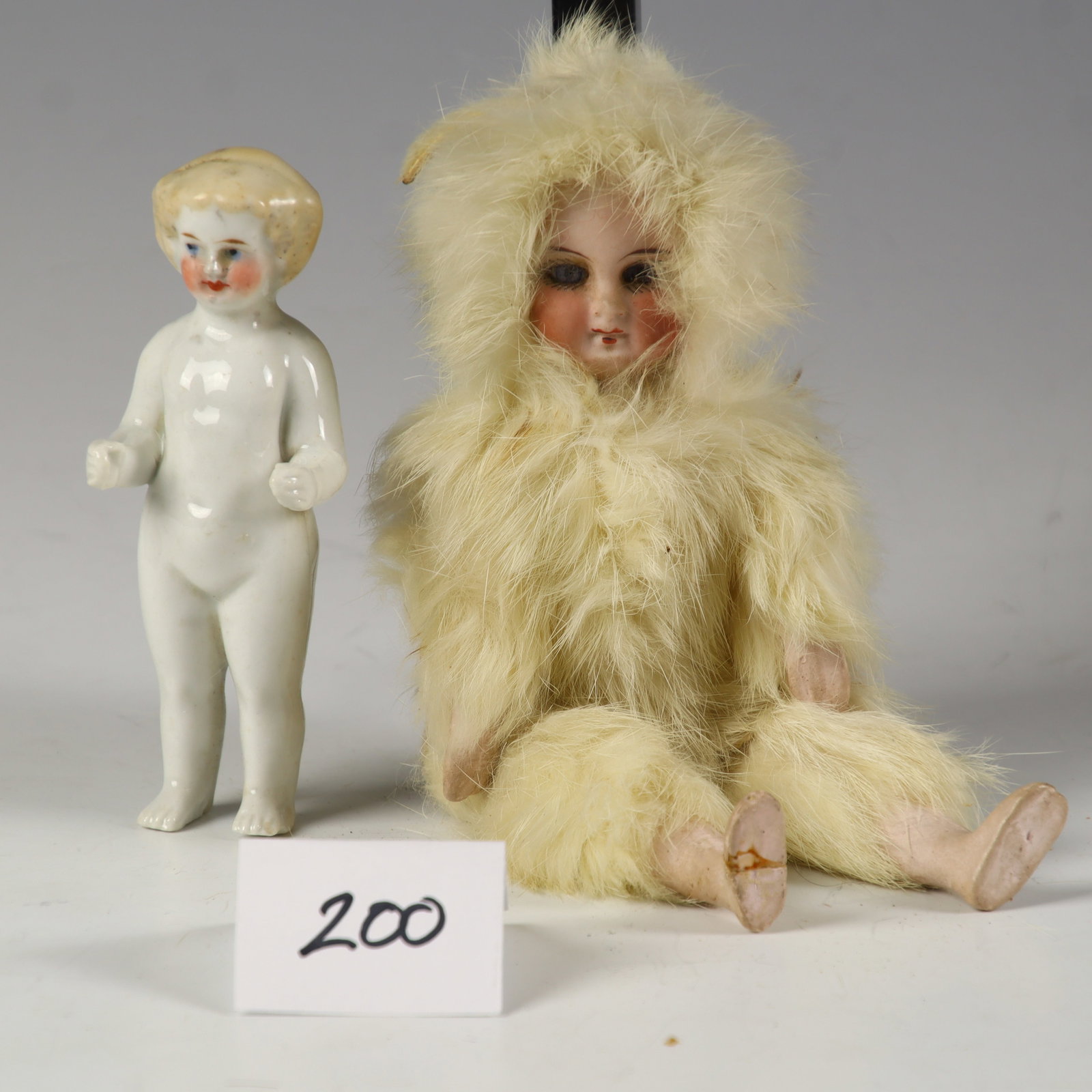 Two Antique Dolls: Two Antique Dolls, one is a porcelain and fur doll possibly German 7.5 inches tall, one is porcelain 4 inches tall