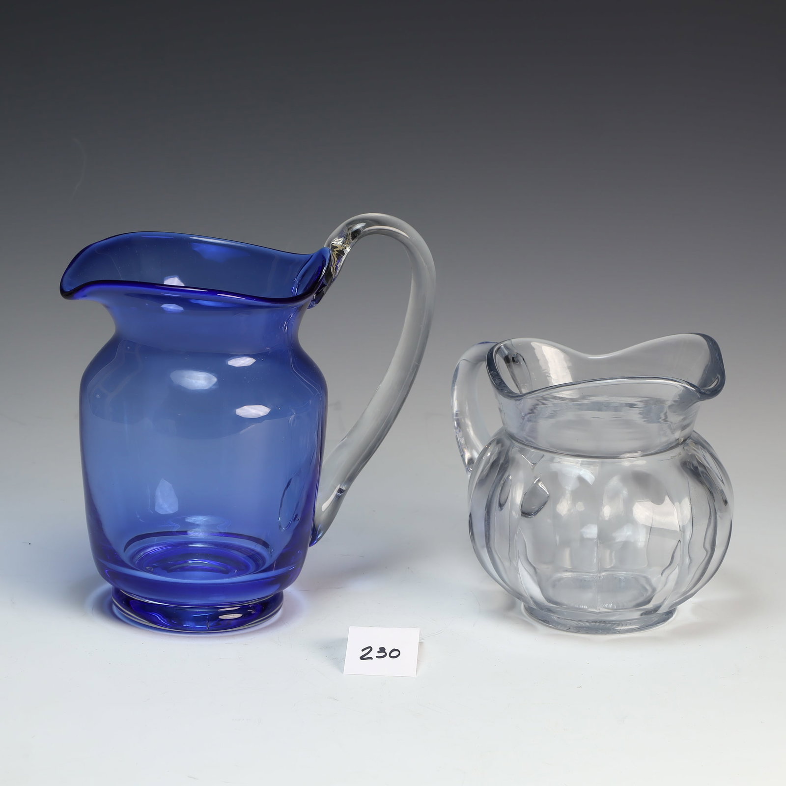 Vintage Chippendale Krystol pitcher and a vintage blue and clear glass handle pitcher: Vintage Chippendale Krystol pitcher and a vintage blue and clear glass handle pitcher 6X7 inches, 8X8.5 inches