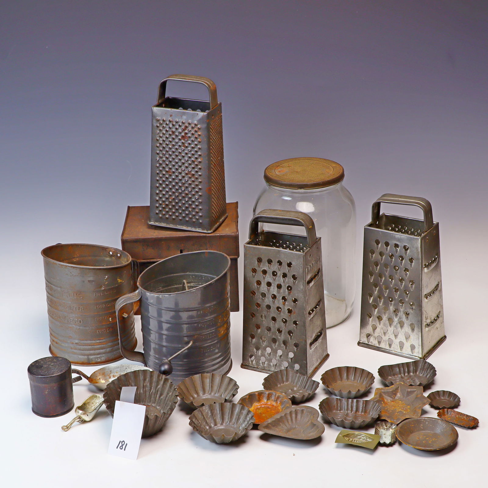 Primitive tin lot: Primitive tin lot, sifters,box, tart molds, glass jar, 2 mini scoops, cast pan 11.5 inches diameter and graters