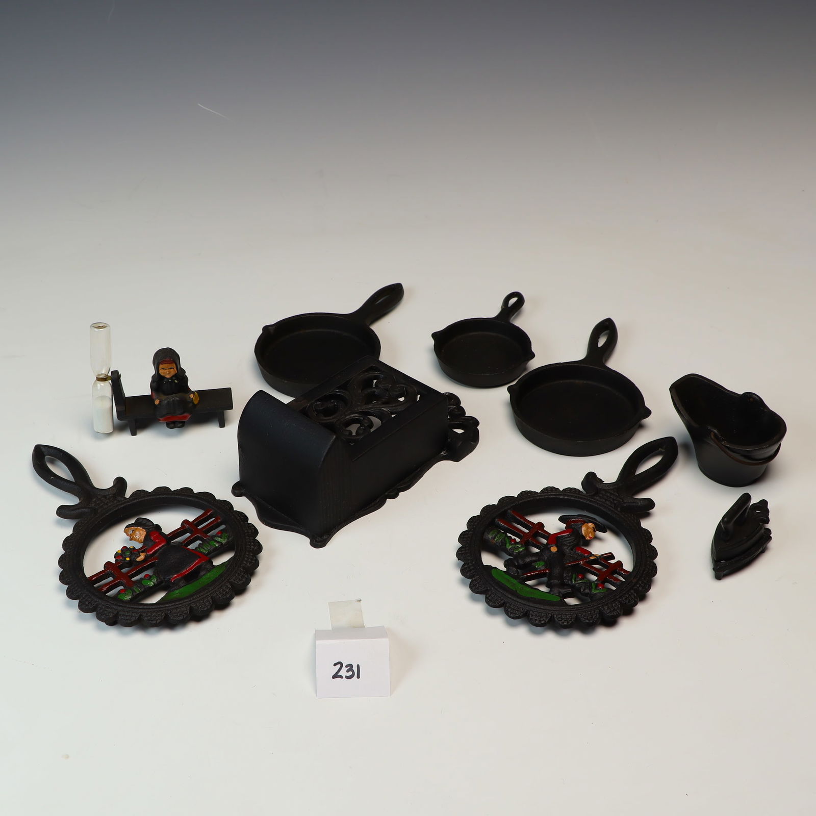 Lot of cast iron collectibles: Lot of cast iron collectibles, trivets, mini pans, match dispenser 7X4 inches, trivets are 8X4.75 inches
