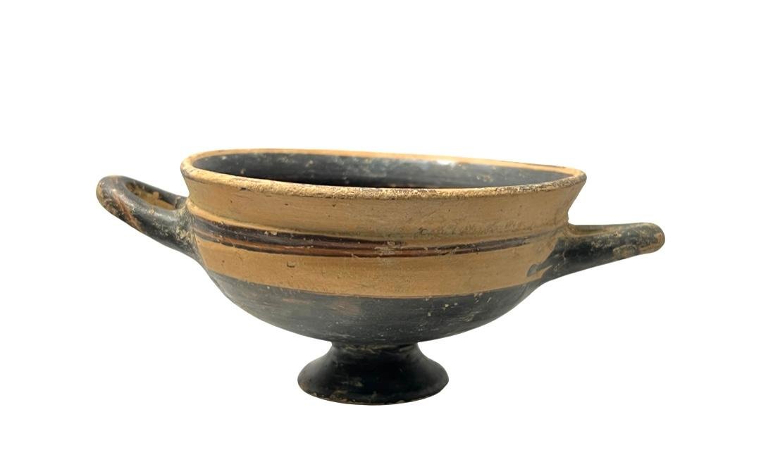 Ancient Greek pottery Kylix Circa 350 B.C.: Ancient Greek pottery Kylix Circa 350 B.C. A pottery Kylix with twin handles. Provenance: Ex Private New York City collection Size: 19 cm x 8 cm across handle span good condition: chips, and abrasions