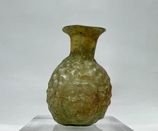 Roman light green glass putto Janus head flask. (1 of 4)