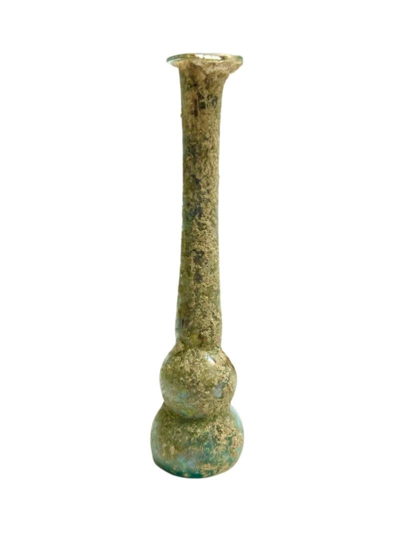 Ancient Roman glass unguentarium with two-part body.: Roman glass unguentarium with two-part body, 2nd - 3rd Century BC, the base nearly flat, the neck long and tubular, the mouth flattened with rim folded. intact. Size: 10.5 cm x 2.5 cm Ex private NY Co