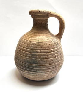 Roman/ Holy Land pottery juglet: Roman pottery juglet, Holy Land, 3rd - 4th Century AD, in pinkish clay with trefoil pouring spout, strap handle, horizontally grooved body. Size: 13 cm x 10 cm.