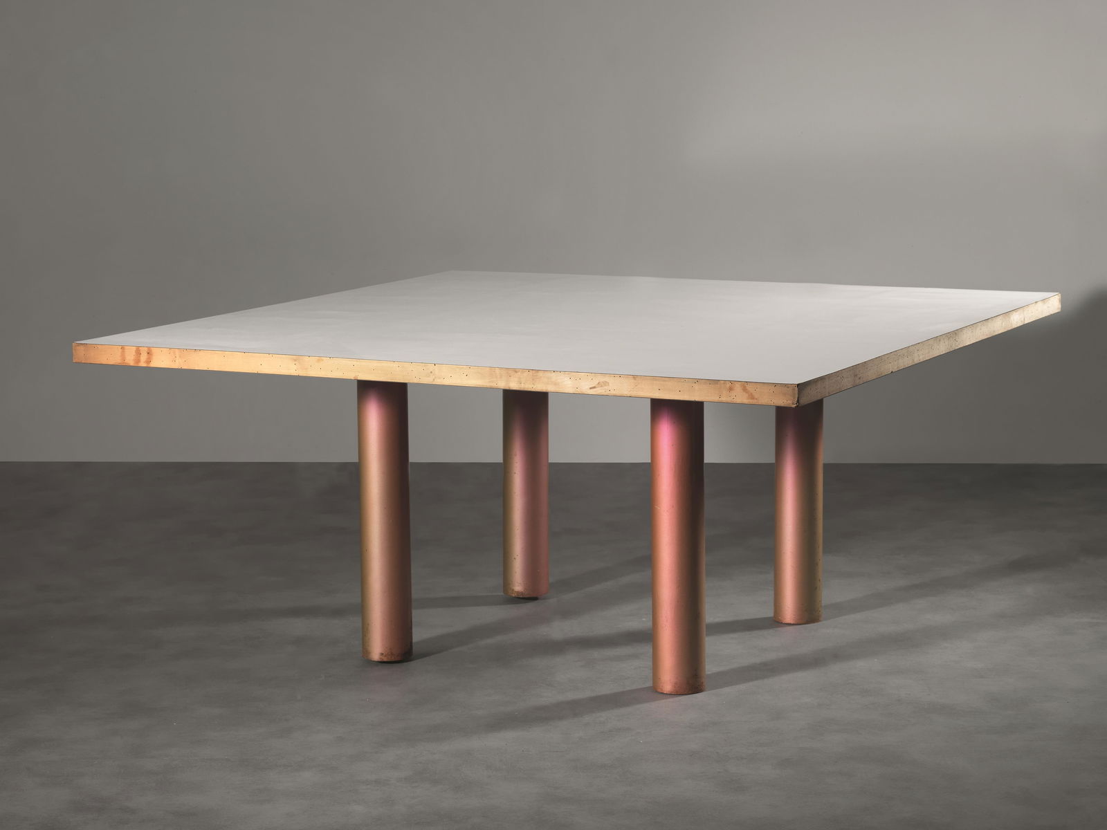 Superstudio Tavolo struttura in metallo verniciato: Superstudio Tavolo struttura in metallo verniciato sfumato dall'oro al rosa, piano in legno laminato bianco Produzione Italia, 1965 circa cm 160x160x72 Questo è il tavolo della sala dell