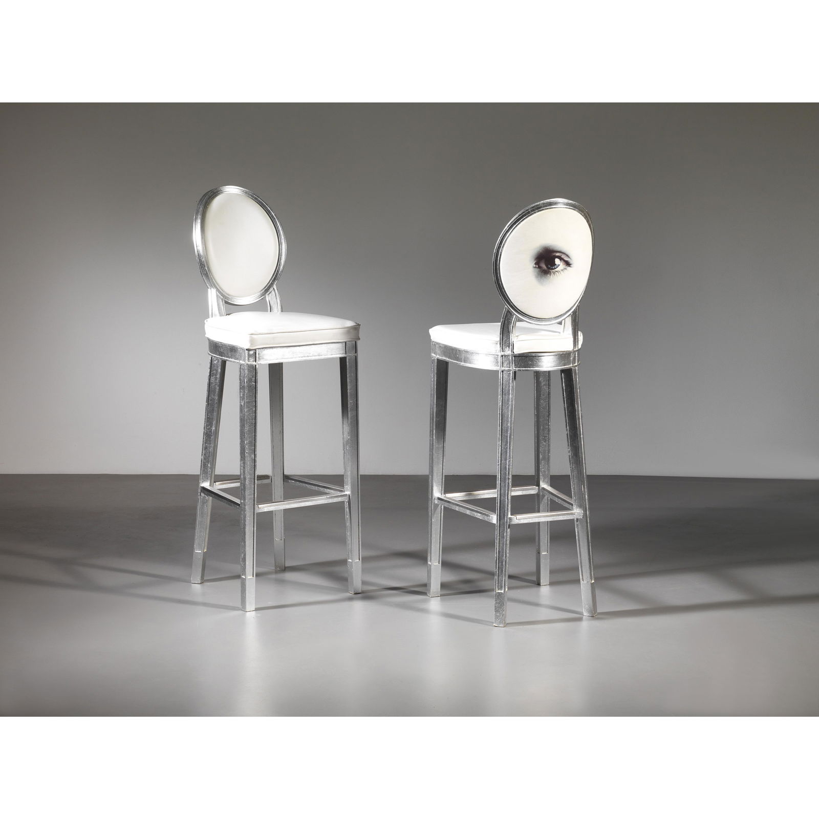 Philippe Starck (Parigi, 1949) A COUPLE OF STOOLS : WOODEN STRUCTURE, WHITE FABRIC UPHOLSTERED COPPIA DI SGABELLI struttura in legno a foglia argento, imbottiti e rivestiti in tessuto nei toni del bianco Produzione Inghilterra, 1998 Gli sgabelli proven