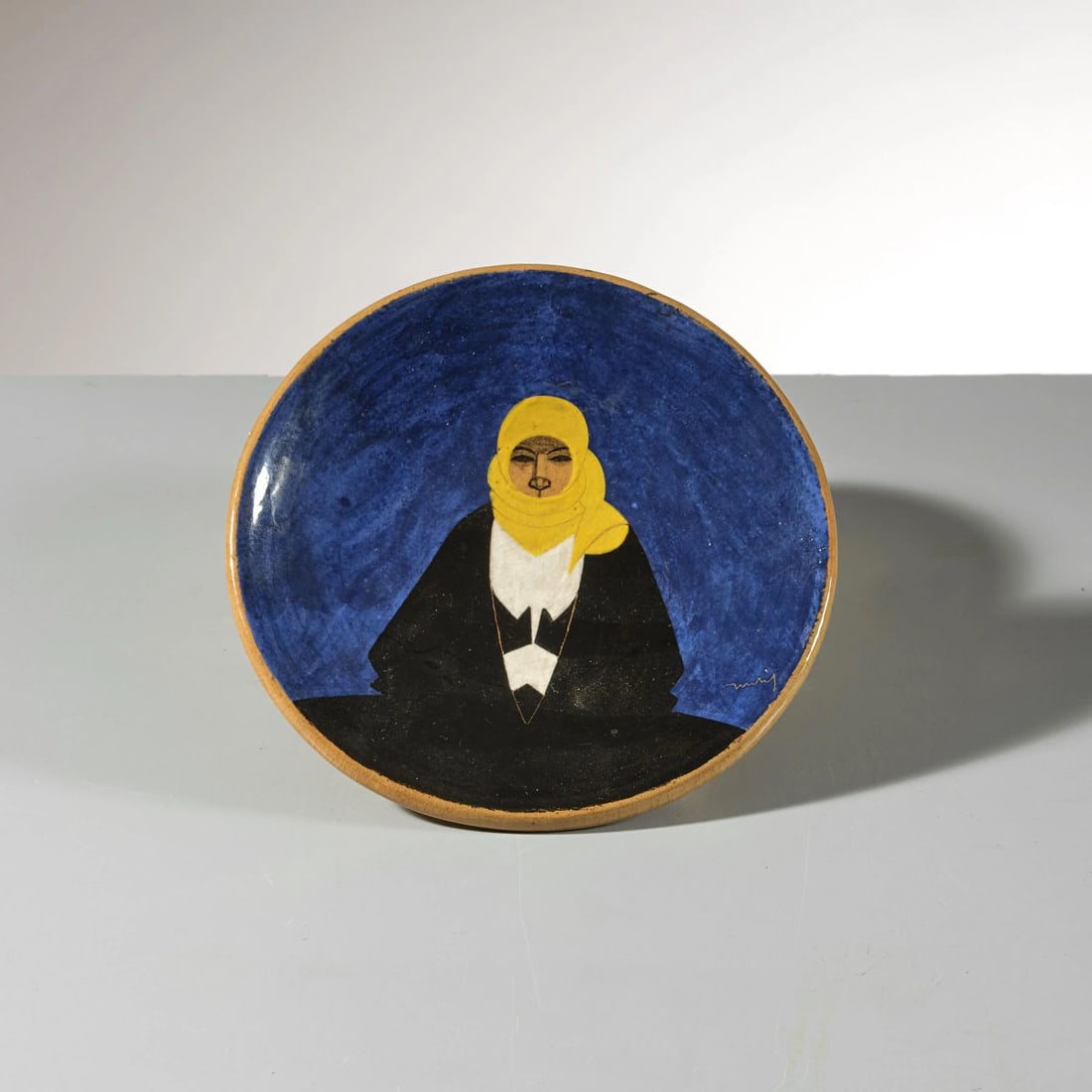 Federico Melis CERAMIC PLATE: Federico Melis (Bosa, 1891 - Urbania, 1969) CERAMIC PLATE PIATTO in ceramica con fondo blu marchio e etichetta del produttore sul fondo firmato sul fronte a destra Produzione Bottega d’arte Ceramica