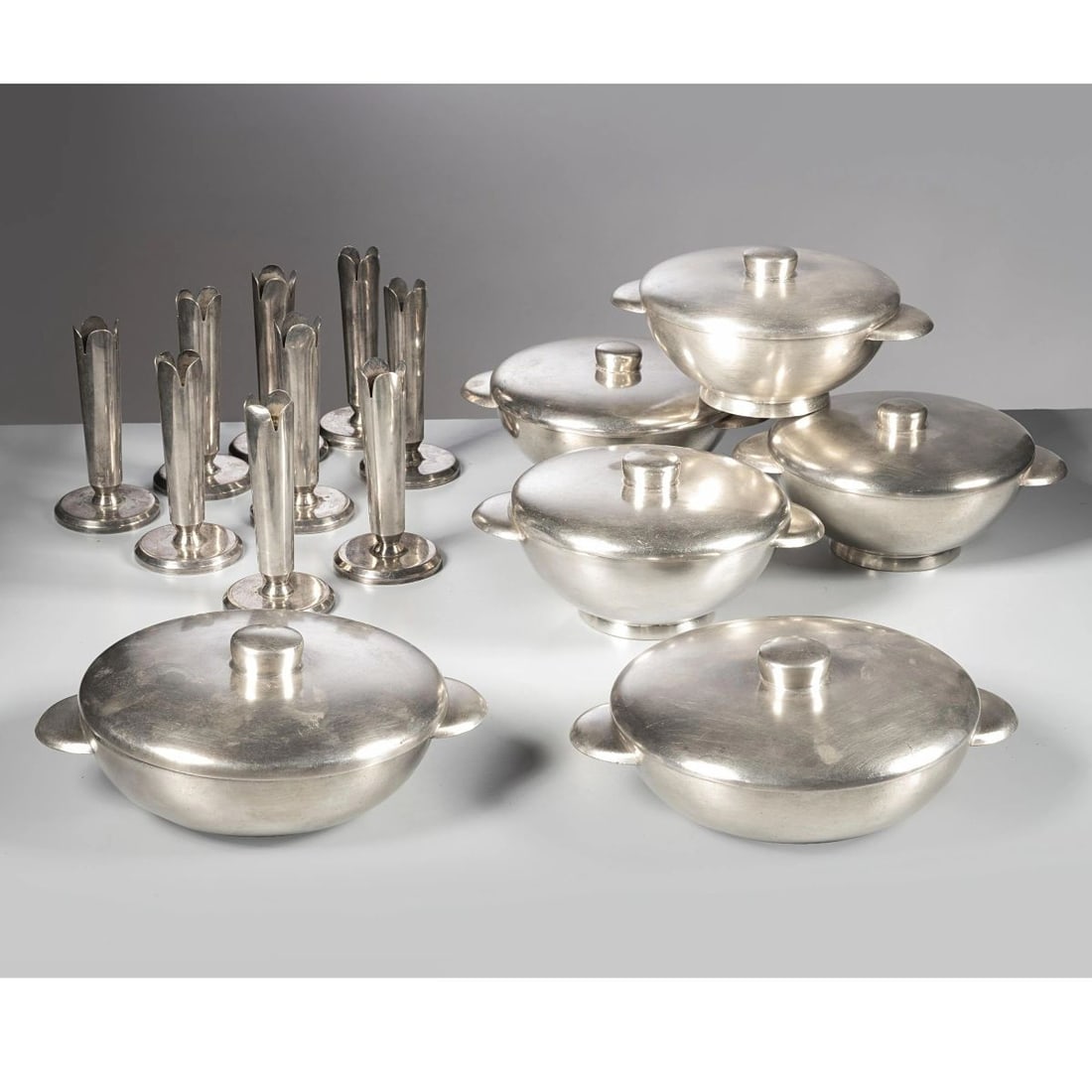 Gio Ponti: Gio Ponti (Milano, 1891 - 1979) SIX BOWLS AND NINE CANDLE HOLDER SEI CIOTOLE E NOVE PORTACANDELE in metallo Produzione Sambonet e Uga, Italia, 1960 circa punzone del produttore