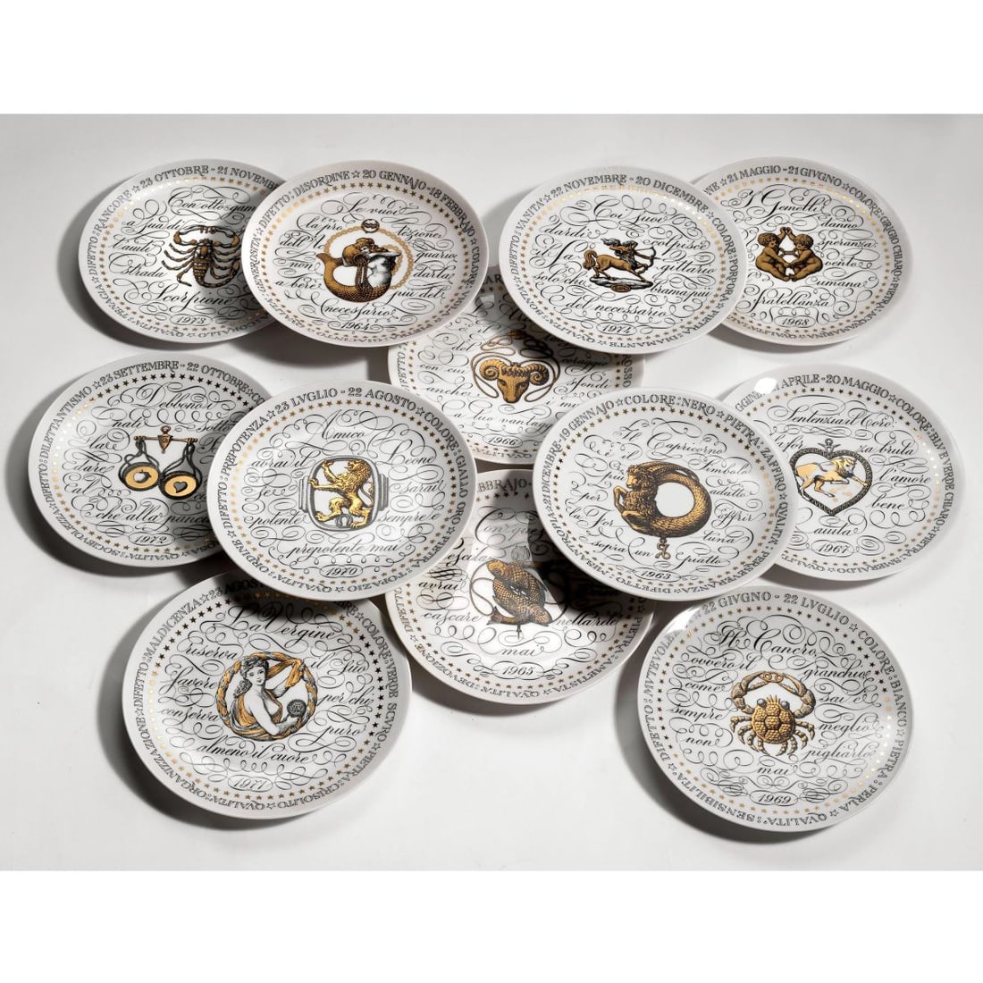 Fornasetti: Fornasetti «ZODIACI» SERIES TWELVE PORCELAIN PLATES DODICI PIATTI DELLA SERIE ZODIACO in porcellana Produzione Fornasetti, Milano, 1965 circa marchio del produttore sul