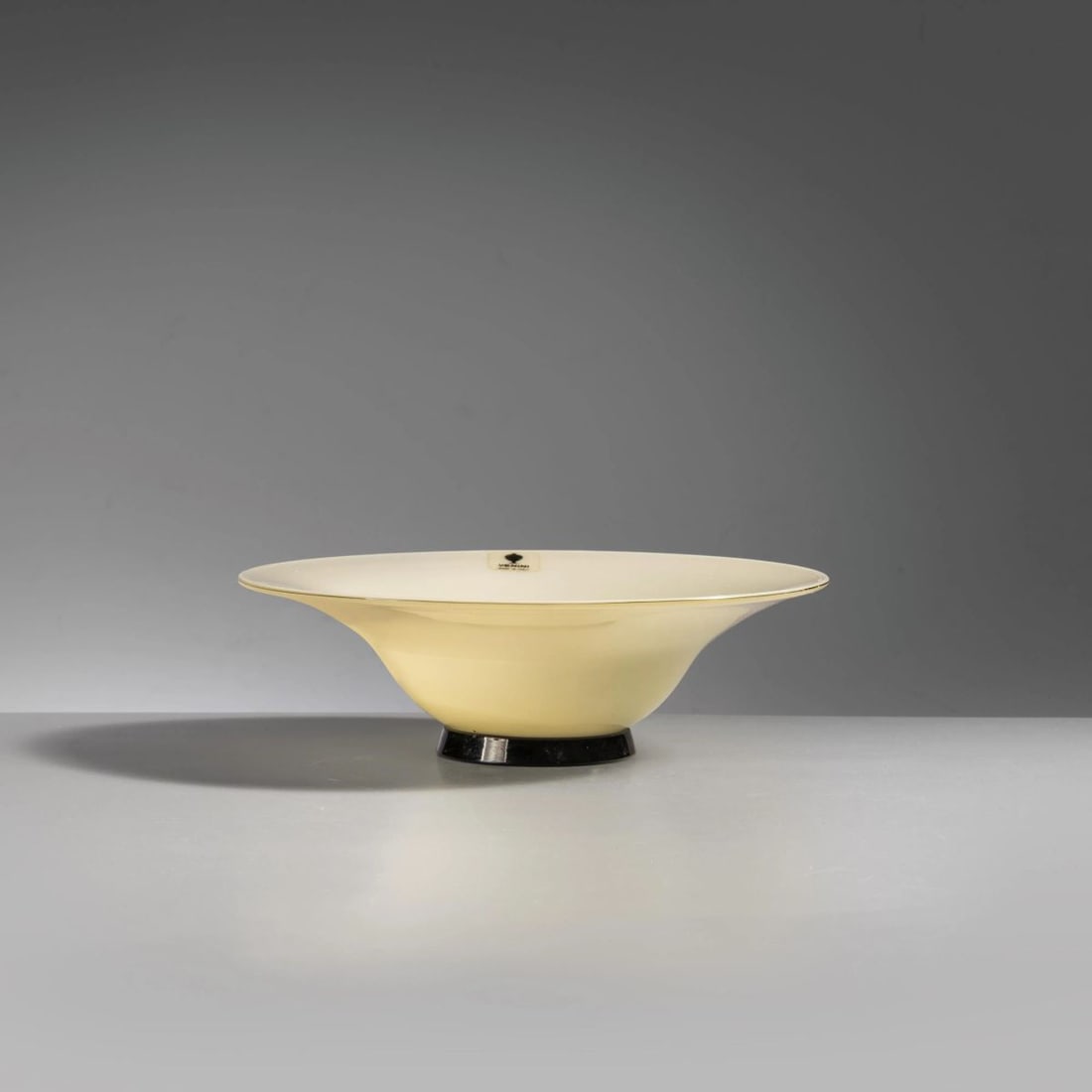 Venini: Venini YELLOW AND BLACK GLASS PLATE ALZATA in vetro nei toni del giallo e del nero Produzione Venini, Murano, 1982 firmato e datato a punta sul fondo adesivo del produttore alt. cm 5,5 e diam.
