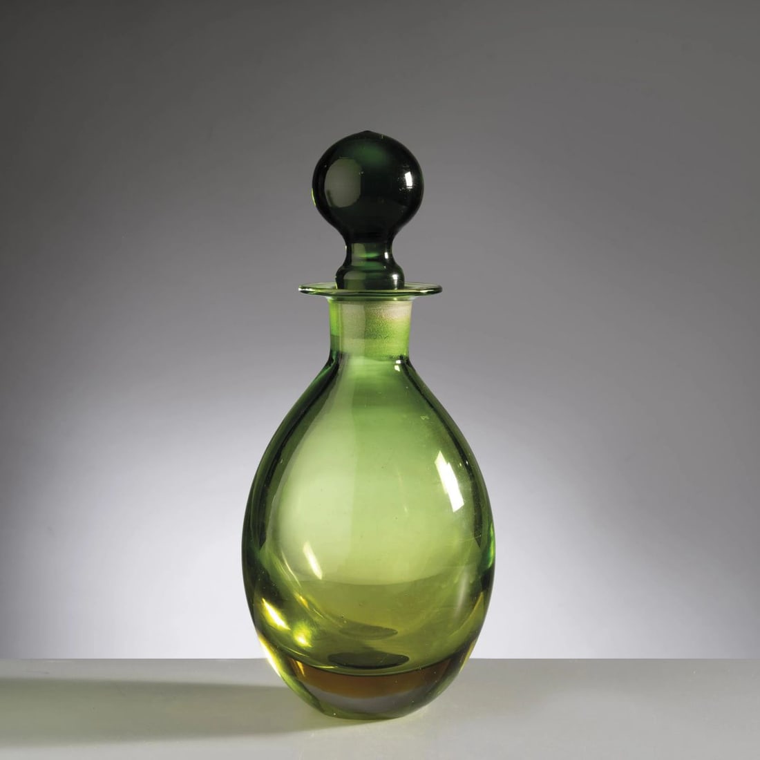 A GREEN GLASS BOTTLE: A GREEN GLASS BOTTLE UNA BOTTIGLIA in vetro nei toni del verde Produzione Seguso, Italia, 1965 circa alt. cm 28 e diam. cm 14