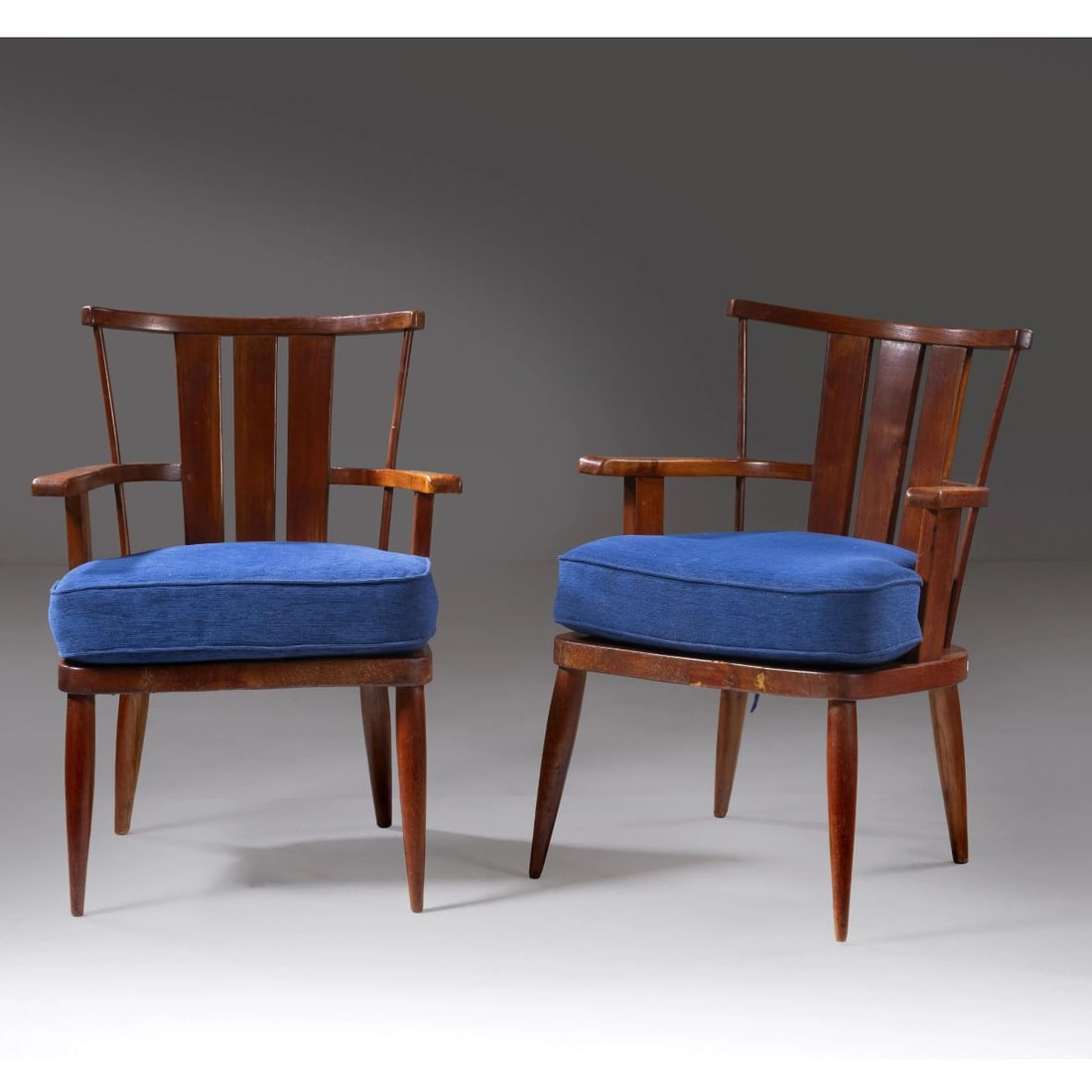 A COUPLE OF ARMCHAIRS: A COUPLE OF ARMCHAIRS, WOODEN STRUCTURE, BLUE FABRIC UPHOLSTERED CUSHIONS COPPIA DI POLTRONE in legno, cuscini imbottiti e rivestiti in tessuto nei toni del blu Produzione Italia, 1940 circa cm