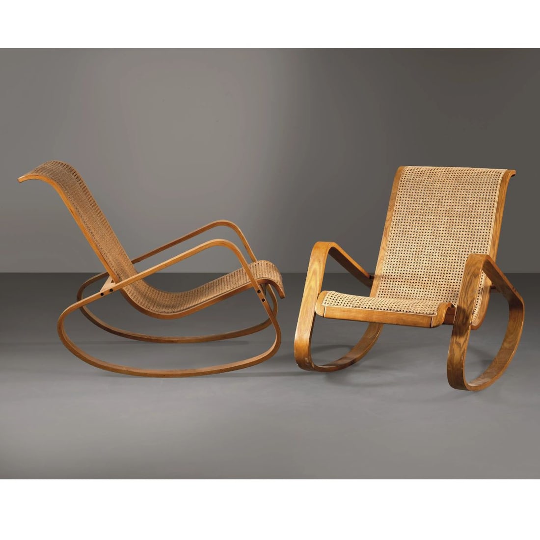 Luigi Crassevig: Luigi Crassevig (Sec. XX) A COUPLE OF «WO» ROCKING ARMCHAIRS, WOODEN STRUCTURE, WICKER SEATS COPPIA DI POLTRONE A DONDOLO MODELLO WO in legno, seduta in paglia Produzione Italia,