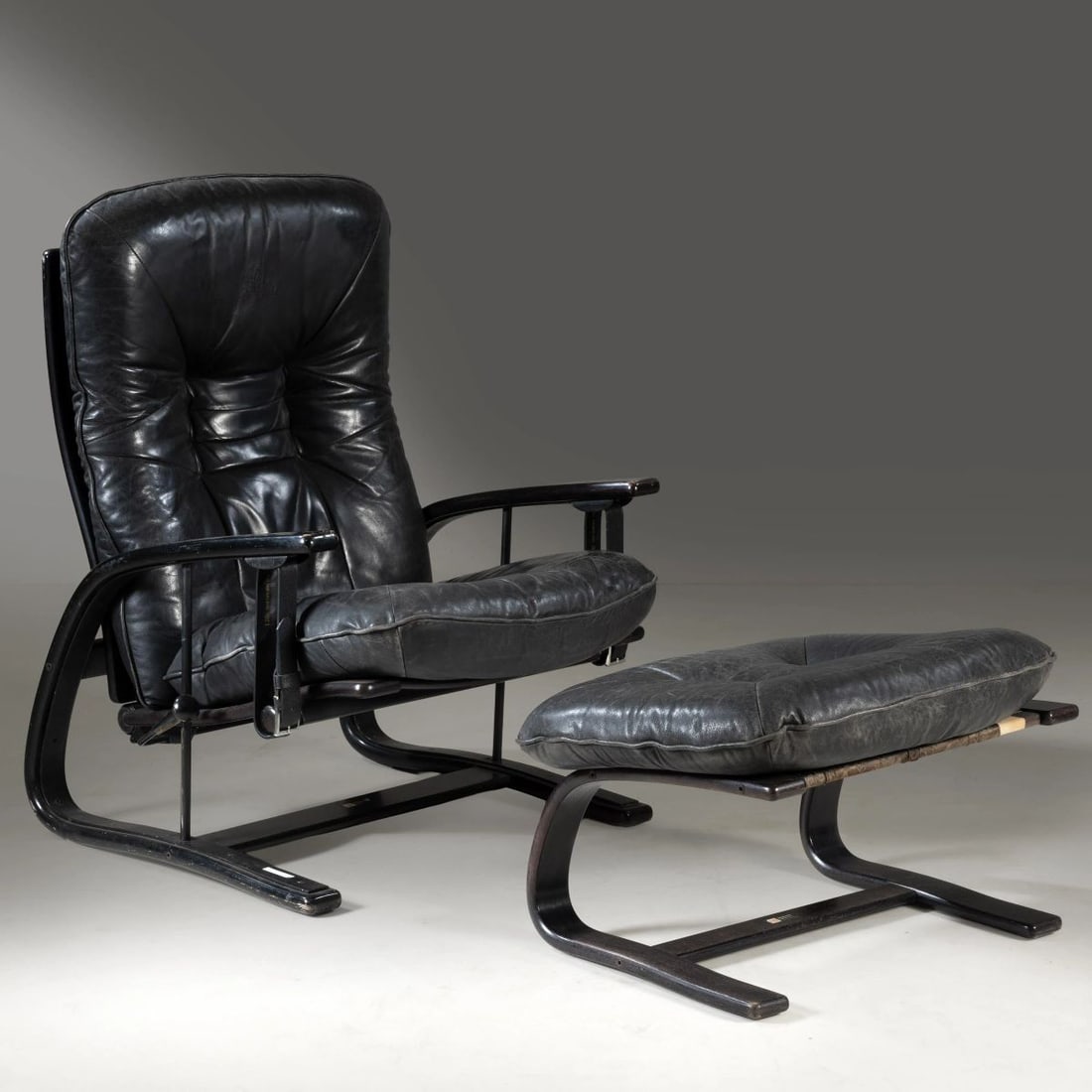 Arnt Lande: Arnt Lande (1920 - 2006) ARMCHAIR WITH FOOTREST, WOODEN STRUCTURE POLTRONA MODELLO PANTER struttura in legno, imbottita e rivestita in pelle nei toni del nero Produzione Westnofa, Norvegia, 1970