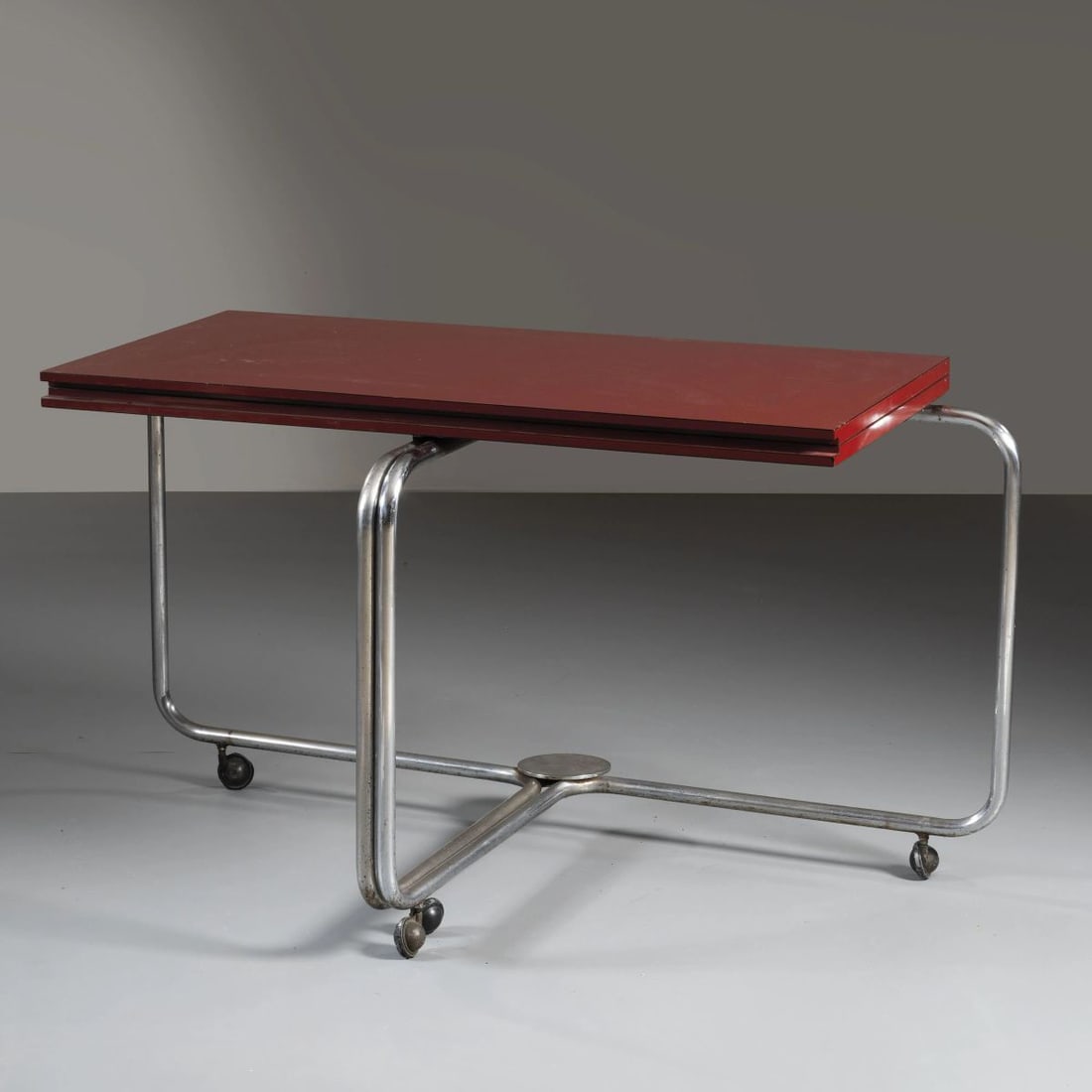 Pietro Salmoiraghi: Pietro Salmoiraghi (1941) EXTENDABLE TABLE, WOODEN STRUCTURE, RED LAMINATED WOOD TOP UN TAVOLO APRIBILE struttura in metallo, ripiano in legno laminato nei toni del rosso Produzione Italia, 1935