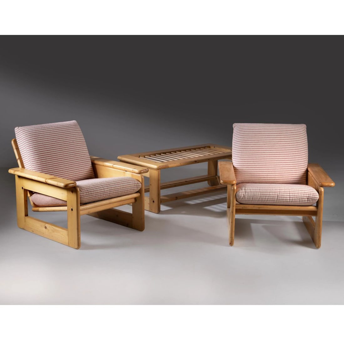 A LOW TABLE AND TWO ARMCHAIRS: A LOW TABLE AND TWO ARMCHAIRS TAVOLO BASSO E DUE POLTRONE in legno, cuscini imbottiti e rivestiti in tessuto nei toni del rosso e del bianco Produzione Italia, 1970 circa tavolino cm H43xL60xP120 polt
