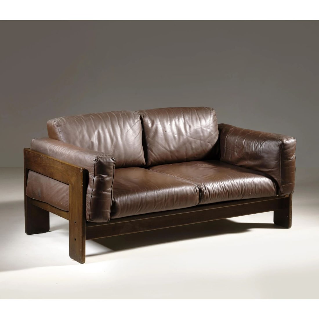 Afra e: Afra e (Montebelluna, 1937 - Trevignano, 2011) Tobia Scarpa (Venezia, 1935) «BASTIANO» SOFA, WOODEN STRUCTURE, BROWN LEATHER UPHOLSTERY DIVANO MODELLO BASTIANO in legno, imbottito e rivestito in