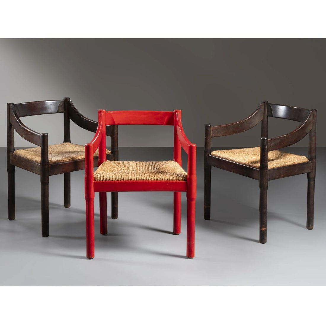 Vico Magistretti: Vico Magistretti (Milano, 1920 - 2006) THREE «CARIMATE» CHAIRS, BROWN AND RED LACQUERED WOODEN STRUCTURE, STRAW SEAT TRE SEDIE MODELLO CARIMATE in legno laccato nei toni del rosso e del marrone e