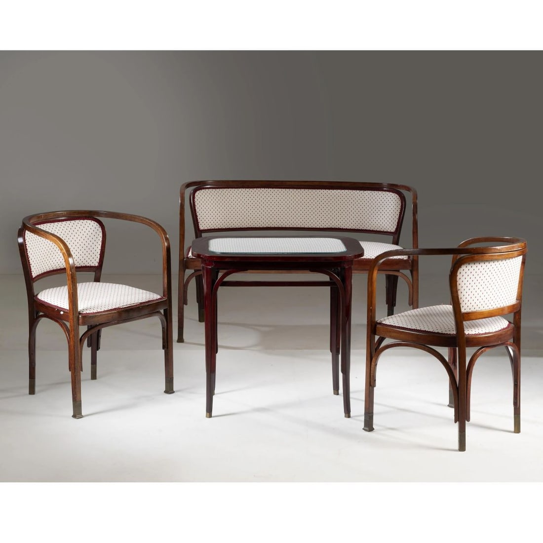 Gustav Siegel: Gustav Siegel (Vienna, 1880 - 1970) DIVANETTO, DUE POLTRONE E UN TAVOLO BASSO MODELLO 715 in legno, imbottiti e rivestiti in tessuto nei toni panna adesivo del produttore sul fondo Produzione