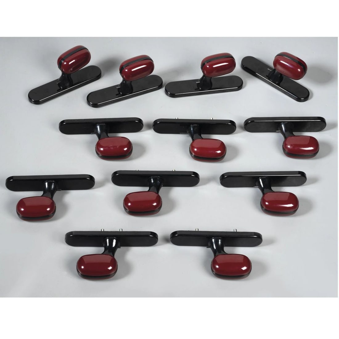 Luigi Caccia Dominioni: Luigi Caccia Dominioni (Milano, 1913 – 2016) DODICI MANIGLIE DA FINESTRA MODELLO MONTECARLO in materiale plastico nei toni del rosso e del nero Produzione Italia, 1975 circa marchio del