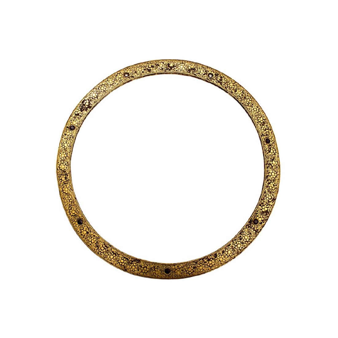 THROWING QUOIT CHAKRA, INDIA: A sharpened edge steel ring covered on both sides with gold koftgari and set with seven (one missing) garnets or rubies. A rare item. Diameter: outside 9.4 in., inside 8 in. 19th Century, North India.