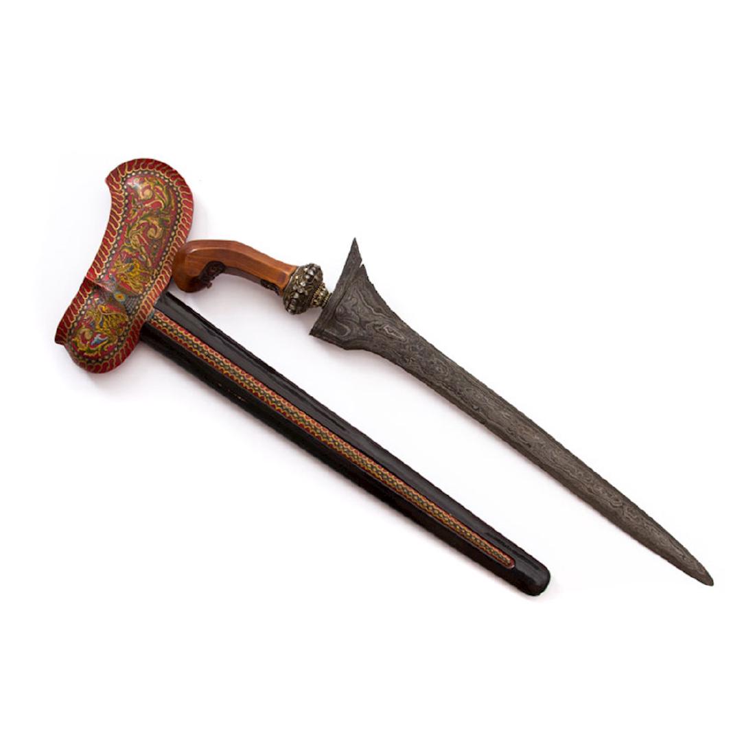 KRIS DAGGER WITH GEMSTONES, JAVA: A stunning example of a kris art with straight double edged blade, the hilt is curved horn, wrangka is of painted wood. The sheath is laquired brass, the silver gilt selut (hilt fitting) is set with g