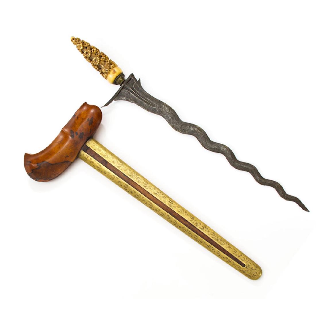 KRIS DAGGER, JAVA: A superb example of Central Java Kris art. Old blade with characteristic ukiren (hilt) with gilt brass selut and mendak. Wooden scabbard is mounted in brass. Beautifully carved grip. * Please revie