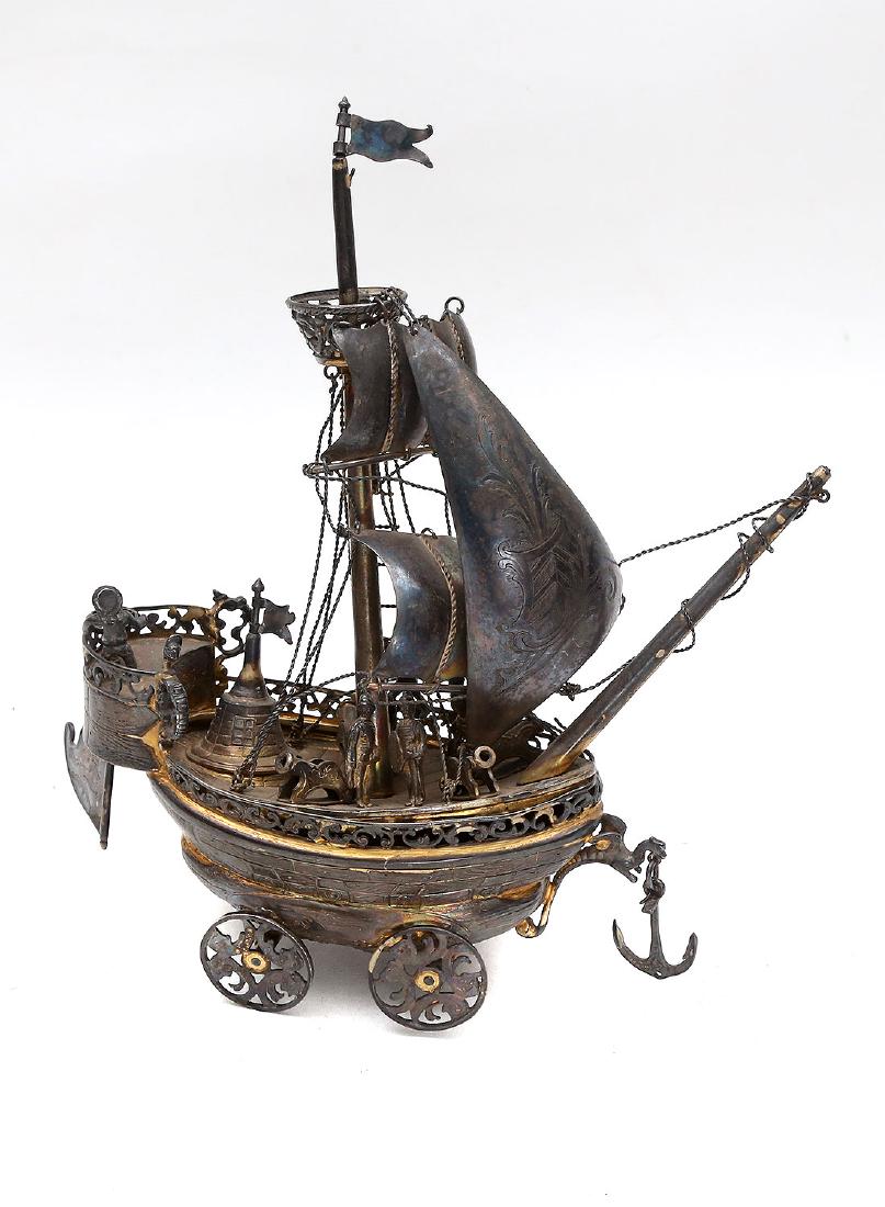 WHEELED DUTCH OR GERMAN GILDED SILVER NEF, 19TH C.: Dutch or German gilded silver nef designed as a wheeled ship under sail, six sailors inhabit the deck, four cannons and rigging. Silver hallmark on the bottom. Sea dragon masthead, ca. 1880. Total wei
