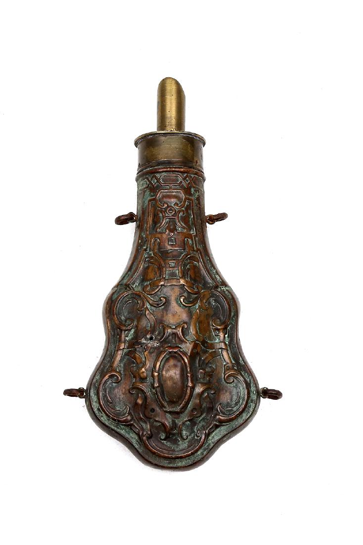 BRASS J & J.W. HAWKSLEY COPPER & BRASS POWDER FLASK: Brass J. & J.W. Hawksley of Sheffield powder flask. Elaborately shaped copper body with embossed ribbon and medallion decoration on both sides, brass nozzle. Mid-19th century. Dimensions: L: 8 1/2 in.