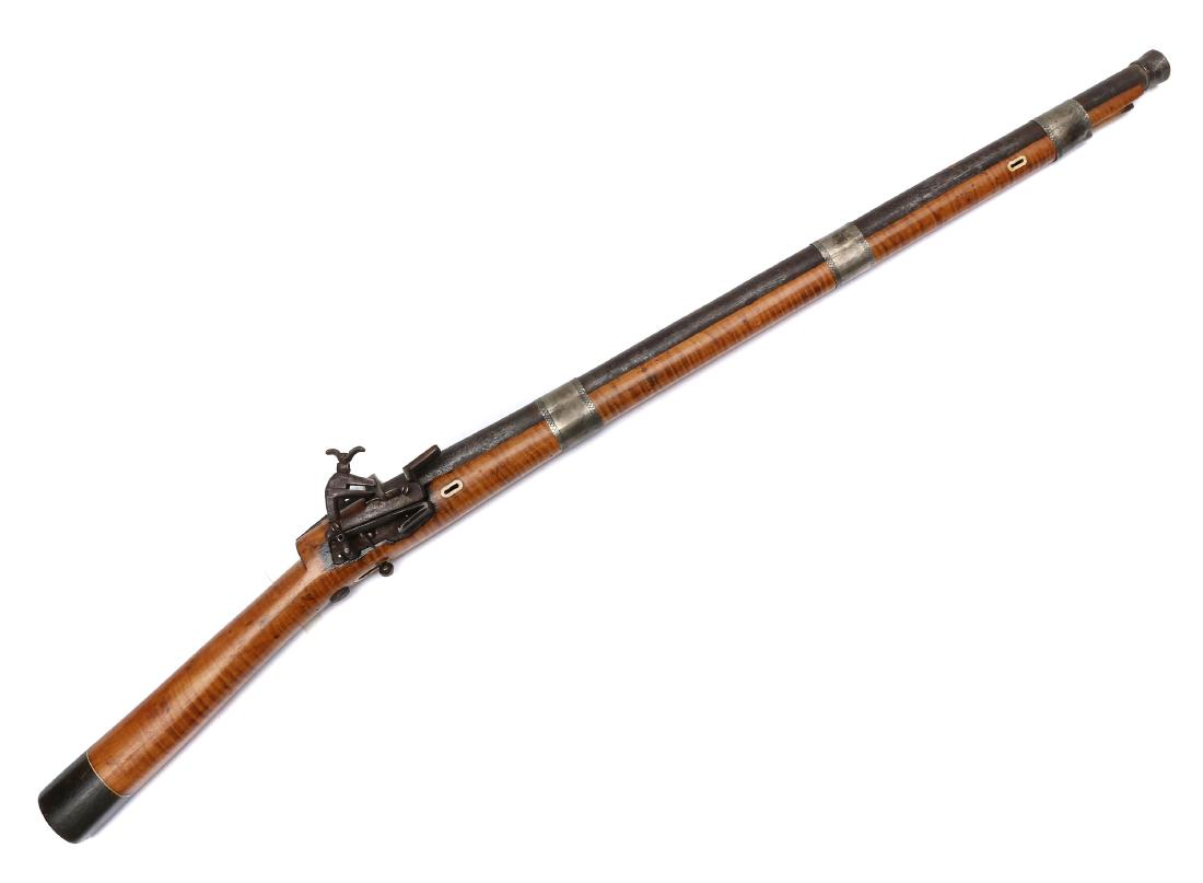 RARE CAUCASIAN FLINTLOCK CARBINE, 19TH C.: Flintlock musket with steel lock in functional condition, silver barrel bands, wooden stock and butt plate. Dimensions: L: 37 1/2 in., (95 cm.)