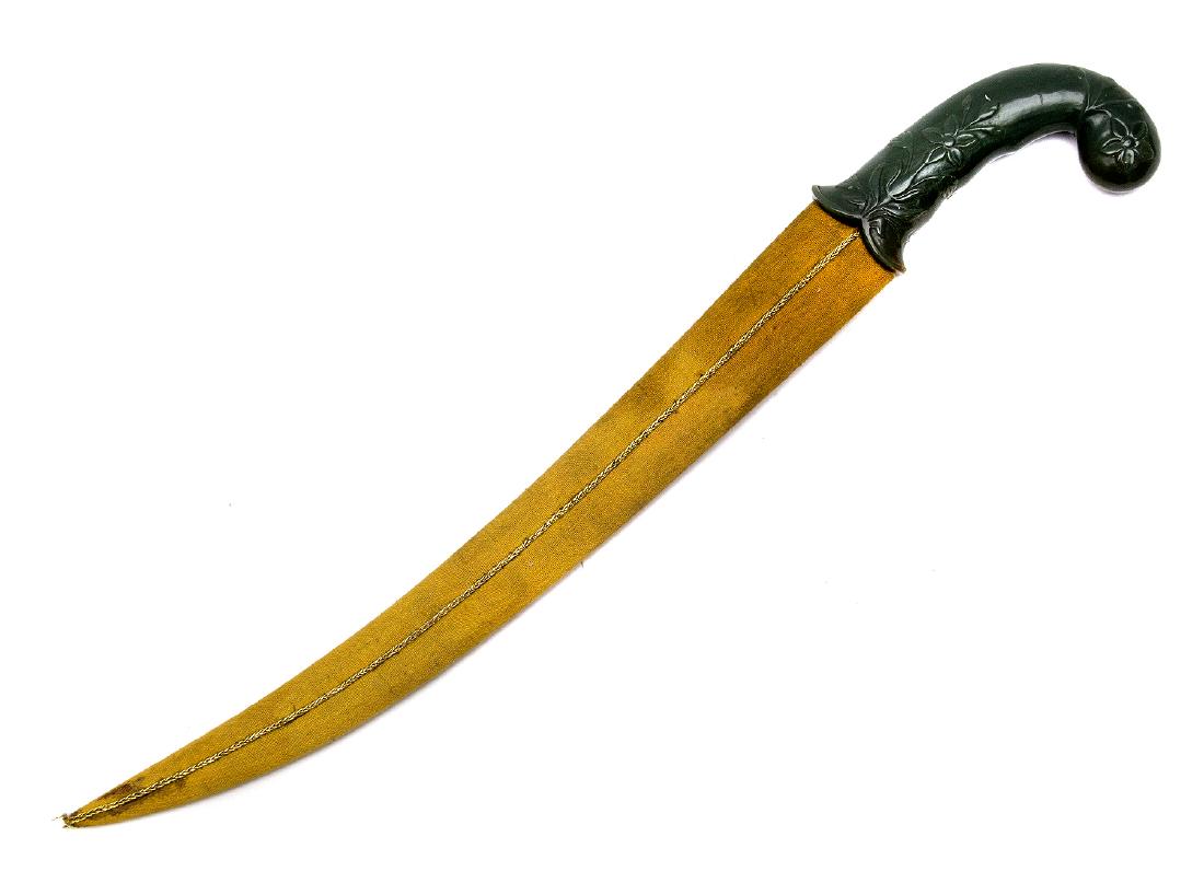 INDIAN MUGHAL STYLE DAGGER WITH KOFTGARI: With richly decorated blade, carved jade hilt with floral design, wooden scabbard covered with fabric. Dimensions: L: 19 1/4 in., (49 cm.)