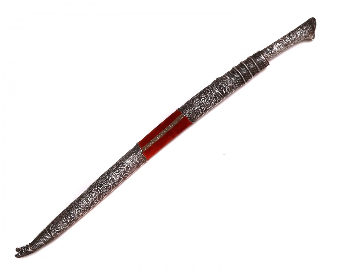 SILVER MOUNTED OTTOMAN PREMIERE ISLAMIC YATAGAN: Ottoman Empire repousse silver mounted yatagan with characteristic re-curved blade, wooden scabbard covered with red velvet. Silver eared pommel. Ca. first half of the 19th century. Dimensions: L: 32 