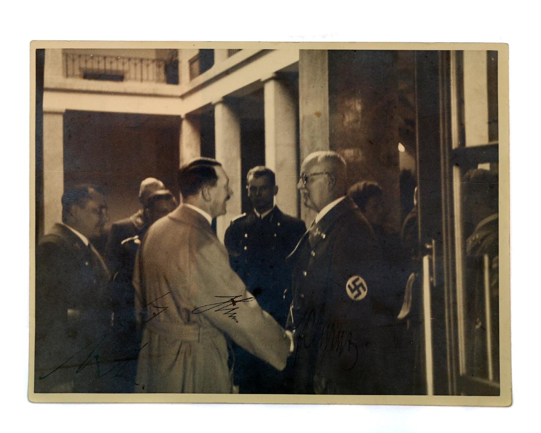 SIGNED PHOTOGRAPH OF HITLER, BORMANN, AND SHWARZ: Photograph depicting Adolf Hitler, Martin Bormann, and Franz Xaver Schwarz (Reich Treasurer Of The NSDAP) with original signatures of each of them. Possibly taken at the Salzburg Residence in 1938. St